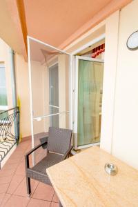 a balcony with a chair and a table and a window at Villa del Mar in Niechorze