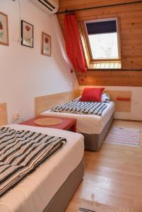 2 camas en una habitación pequeña con ventana en Lenart House 2, en Siófok
