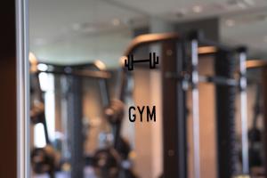 a row of exercise equipment in a gym with the word gym at Hotel Oriental Express Fukuoka Nakasu Kawabata in Fukuoka