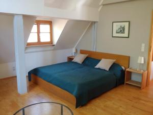 a bedroom with a blue bed in a attic at Pension Fuchsmühle in Rothenburg ob der Tauber
