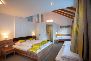 a bedroom with two beds with yellow pillows at Apart Avenzio in Kappl