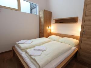 - une chambre avec un lit et 2 serviettes dans l'établissement Comfy apartment with two bathrooms, in Neukirchen, à Neukirchen am Großvenediger