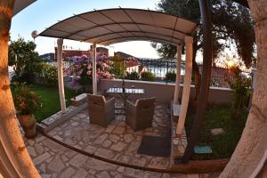 a gazebo with two chairs in a yard at Nika Family Apartments in Dubrovnik