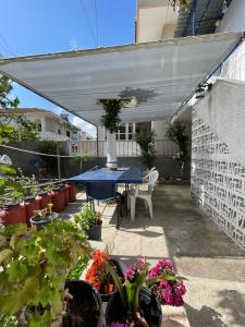 eine Terrasse mit einem blauen Tisch und einigen Pflanzen in der Unterkunft Penelope in Vrontádos