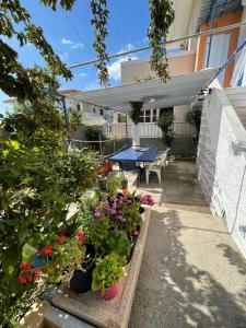 een patio met een tafel en wat bloemen en planten bij Penelope in Vrontádos