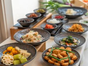 a table topped with bowls of different types of food at ART HOTEL Miyazaki Sky Tower in Miyazaki