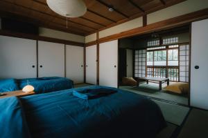 um quarto com duas camas e um banco em NIPPONIA Tomo Port Town em Fukuyama