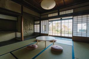 a room with a table and two ottomans at NIPPONIA Tomo Port Town in Fukuyama