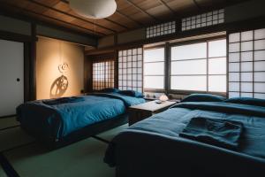 福山NIPPONIA Tomo Port Town的带窗户的客房内设有三张床。