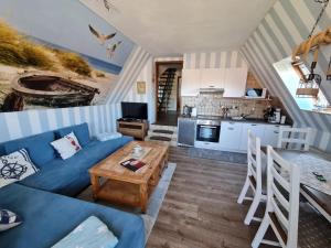 a living room with a blue couch and a table at Haus Seestern in Dornumersiel