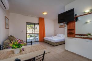 Naẖal Ya‘alonKibbutz Ketura Guest House的带沙发、床和桌子的客厅