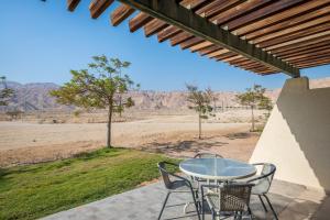 Naẖal Ya‘alonKibbutz Ketura Guest House的庭院内的桌椅,享有沙漠美景