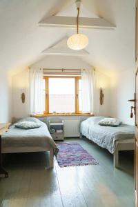a bedroom with two beds and a window at Guest House Viga in Pāvilosta