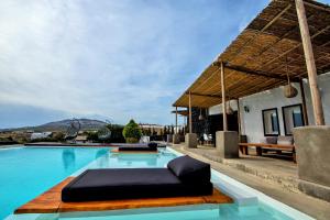 a swimming pool with a black chaise lounge next to a house at A&V Sea View Villa in Fira