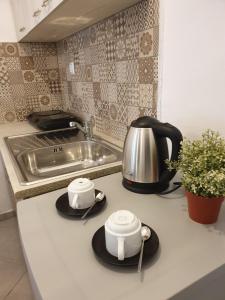 un bancone della cucina con due tazze da tè e un bollitore di V-Suites a Potos