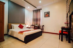 a bedroom with a bed and a desk in a room at Sunflowers Hotel Airport in Ho Chi Minh City