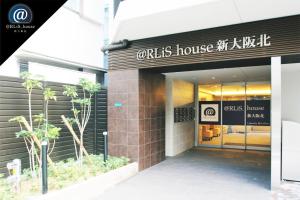 a store with a sign on the front of a building at @RLiS_house新大阪北 in Osaka