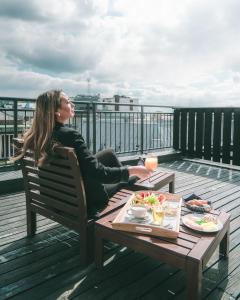
a woman sitting at a picnic table with a plate of food at First Hotel Millennium in Oslo
