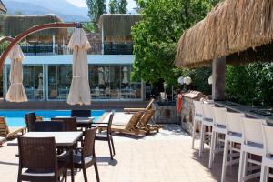 a patio with tables and chairs next to a pool at Green Peace Hotel in Oludeniz