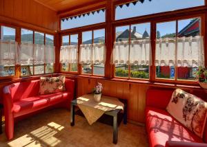 a room with red chairs and a table and windows at Apartamenty i Pokoje Karpacz - centrum Karpacza, parking w cenie! in Karpacz