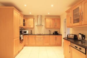 a large kitchen with wooden cabinets and appliances at Ardmullen in Kenmare