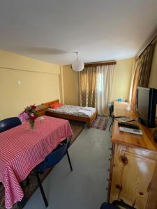 ein Wohnzimmer mit einem Tisch und einem TV in der Unterkunft Penelope in Vrontádos