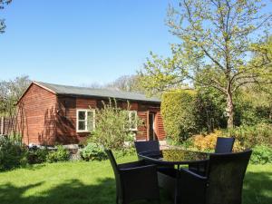 una casa con tavolo e sedie nel cortile di The Garden Lodge a Bridgnorth