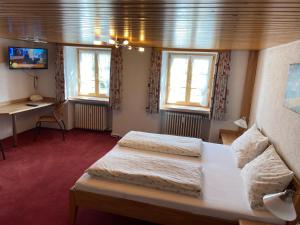 ein Zimmer mit zwei Betten und einem Schreibtisch und Fenstern in der Unterkunft Gasthaus Kalte Herberge in Vöhrenbach