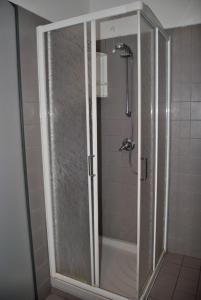 Ono San Pietro的住宿－Ostello Centro Concarena，浴室里设有玻璃门淋浴