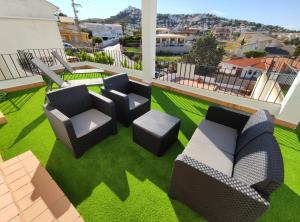 a patio with chairs and tables on the grass at Peñíscola Centro Inmomart in Peniscola