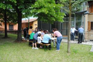 Ono San Pietro的住宿－Ostello Centro Concarena，一群人坐在公园的桌子上