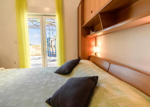 1 dormitorio con 1 cama con 2 almohadas en Apartments Ines, en Cavtat