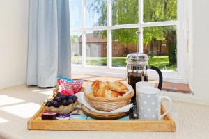 a tray with a basket of bread and a coffee maker at Beachborough Park in Folkestone