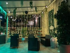 un restaurant avec des lumières, des chaises et des plantes dans l'établissement Hotel Nice, à Viareggio