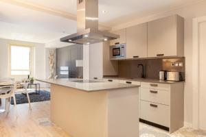 uma cozinha com armários brancos e um forno com placa de fogão em You Stylish City Center Apartments em Barcelona
