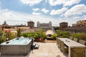 patio con tavolo, sedie e vasca idromassaggio. di Amazing Penthouse Piazza Venezia a Roma