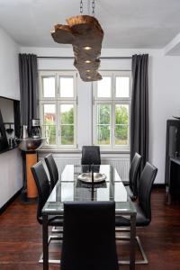 ワイマールにあるFerienwohnung am KunstTurmのガラスのテーブルと椅子のあるダイニングルーム