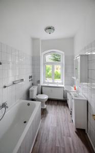 ein weißes Badezimmer mit einer Badewanne, einem WC und einem Waschbecken in der Unterkunft Ferienwohnung Jakob in Tönning