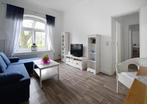 ein Wohnzimmer mit einem Sofa und einem TV in der Unterkunft Ferienwohnung Jakob in Tönning