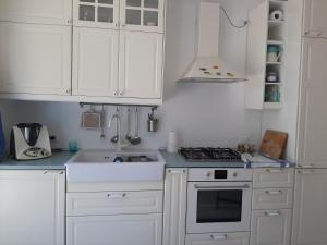 a white kitchen with a stove and a sink at Casa del Leccio in Pulsano