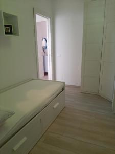 a white room with a bed and a mirror at Casa del Leccio in Pulsano