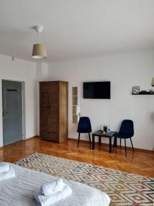 a bedroom with a bed and two chairs and a television at Vila Belmondo in Sovata