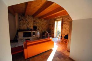 sala de estar con sofá naranja y chimenea en casa storica en Francavilla Marittima