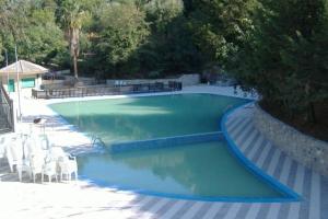 a swimming pool with blue water and white chairs at Casa Storica in Francavilla Marittima