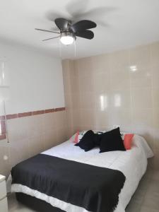 a bedroom with a bed with a ceiling fan at apartamento benalmadena in Benalmádena