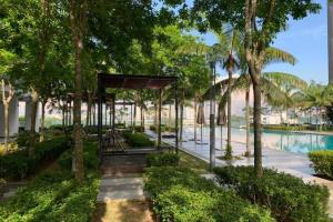 a resort with a pool and trees and a pavilion at Cosy Studio Netflix SelfCheckIn Cyberjaya 1 in Cyberjaya