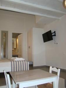 a dining room with a table and a tv on the wall at Efi's Apartments in Plaka Milou