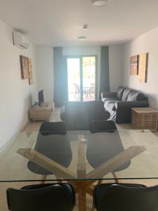een woonkamer met een glazen tafel en stoelen bij Hotel Apartamentos Manilva Sun in Manilva