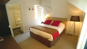 a bedroom with a large bed with red pillows at Hôtel Ar Iniz in Saint Malo