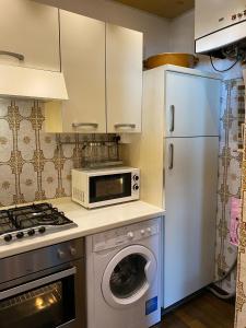 uma cozinha com uma máquina de lavar roupa, um fogão e um micro-ondas em Residenza Casa del Sole Appartamento em Bellaria-Igea Marina